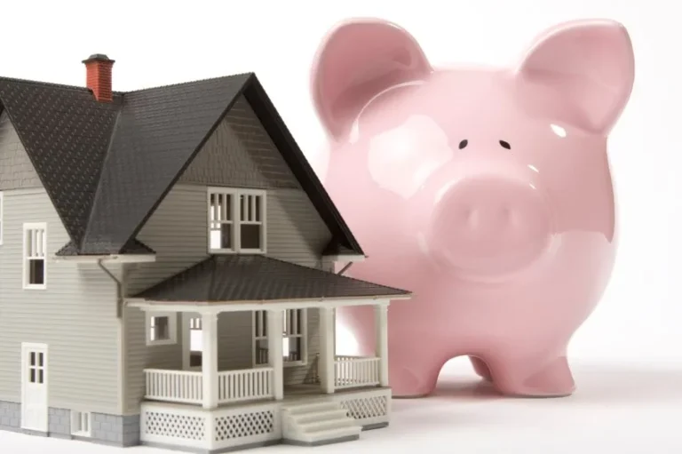 Model house beside a pink piggy bank