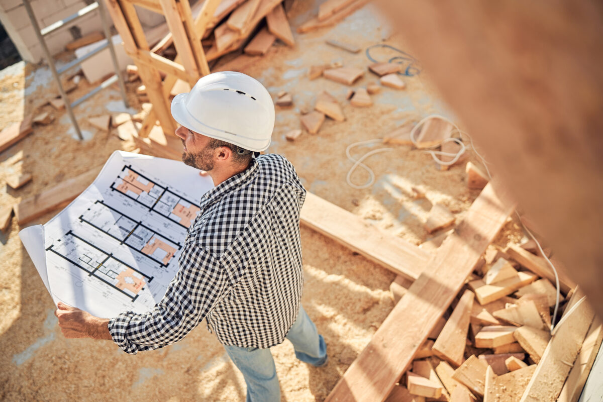 Builder checking the blueprints of a new home