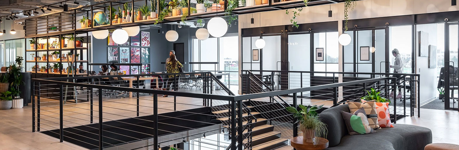 Modern shared workspace interior with mezzanine and planting